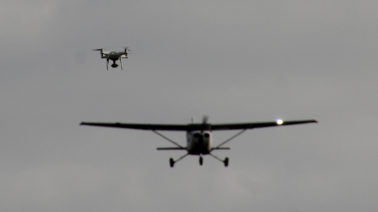 A drone and a small airplane in the air near each other